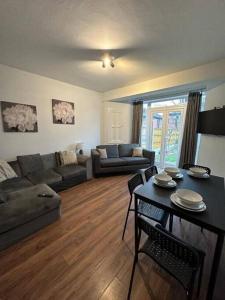 ウォリントンにあるSpacious 4Bedroom House in Warrington - Sleeps 8のソファとテーブルのあるリビングルーム +4枚の写真