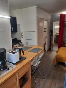 une cuisine avec un comptoir et une table avec un micro-ondes dans l'établissement Duplex14h 1er étage jardinet 1 parking ou studio14B rdc terrasse sans parking, à La Rochelle