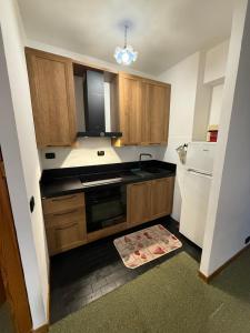 a kitchen with wooden cabinets and a black counter top at Home Beta in Terminillo +8 photos