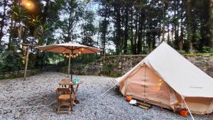 a tent with a table and a chair and a table at Glamping Xicotepec in Xicotepec de Juárez