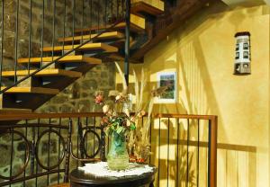 a vase with flowers on a table next to a staircase at El Rincón del Tarabilla in Fermoselle