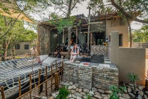 a man sitting on the porch of a house at Grace of Africa, Couples 5 STAR Nature Lodge in Marloth Park