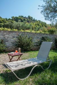 a folding lawn chair and a table in the grass at Diamond Giannopoulos Elea Apartments in Kyparissia