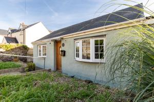 a small blue house with a door and windows at Gorse Cottage - Sea Views Village Centre in Penally