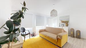 sala de estar con sofá amarillo y planta en Azores Calheta Inn Apartment T3, en Ponta Delgada
