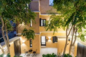une vue extérieure d'un bâtiment avec des arbres dans l'établissement Frida Kahlo - Le petit Bati, à Vólos