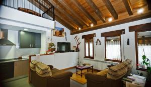 Una sala de estar con dos sillas y una cocina. en El Rincón del Tarabilla, en Fermoselle