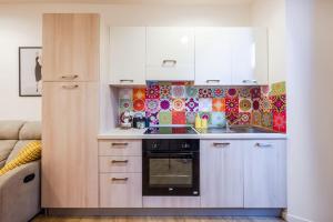 a kitchen with white cabinets and a stove at Varese Centro - Eleganza con comfort e stile in Varese