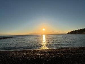a sun setting over the water on a beach at EXCEPTIONNEL !!! VENEZ SEJOURNER DANS LES 3 SUITES D'UN AUTHENTIQUE ANCIEN PALACE DE LA "BELLE EPOQUE" de 1874 !!! UNIQUE !!! in Menton