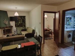 a living room with a couch and a table and chairs at Thodoris Apartment's in Eptalofos