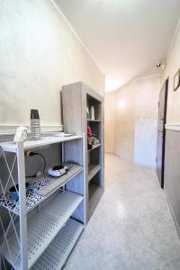 a room with a kitchen with shelves and a refrigerator at Casa Baccanico - a due passi da autostazione in Avellino +1 photo