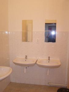 
a bathroom with two sinks and a mirror at Hostel Praha Ládví in Prague
