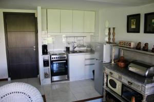 La cuisine est équipée de placards blancs, d'une cuisinière et d'un réfrigérateur. dans l'établissement Esturion de Montoya - La Barra - Punta del Este - 4 pasajeros, à Punta del Este 43 autres photos