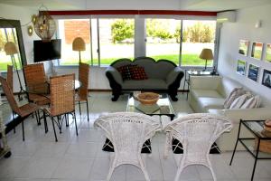 un salon avec des chaises, un canapé et une table dans l'établissement Esturion de Montoya - La Barra - Punta del Este - 4 pasajeros, à Punta del Este