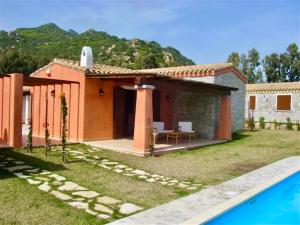 a house with a swimming pool in a yard at ISA-Villas with shared pool in Costa Rei just 500 meters from the sea in Costa Rei