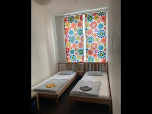 Pokój z dwoma łóżkami przed oknem w obiekcie Hostel Praha Ládví w Pradze