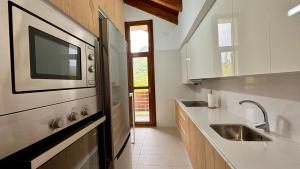 a kitchen with a sink and a microwave at BPIRINEOS-Pico Cerler in Benasque