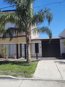 a palm tree in front of a garage at Casa de Fin de semana in María Grande