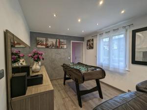 un soggiorno con un tavolo da calcio balilla di Chalet spacieux avec sauna, spa et baby-foot, proche stations de ski - FR-1-589-671 a Ramonchamp