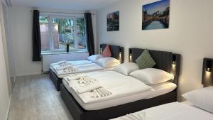 a room with two beds and a window at Barbat Home-Ferienwohnung im Alexanderstraße in Hamburg