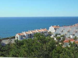 a row of houses with the ocean in the background at Ericeira Sunset Apartment in Ericeira
