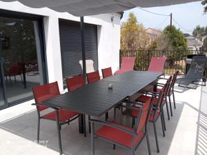 ein Holztisch und Stühle auf einer Terrasse in der Unterkunft Villa neuve à 900 m de la plage in Santa-Lucia-di-Moriani + 4 Fotos