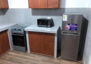 a kitchen with a microwave and a refrigerator at Spacious 3-bedroom and 2 bathroom home with private pool and patio and free Wi-Fi in Calango