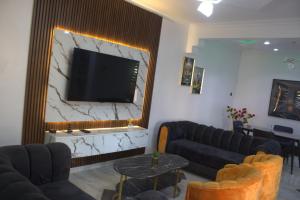 a living room with couches and a flat screen tv at The Vistana 4Bedroom Pearly Gate Estate Ikota VGC Lekki in Igboshere
