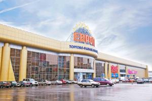 a shopping center with cars parked in a parking lot at Hotel Uyut in Lipetsk