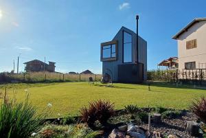 a small black house on top of a yard at Tiny House Cambará in Cambará