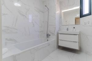 a white bathroom with a tub and a sink at Banana Tree in Câmara de Lobos +15 photos