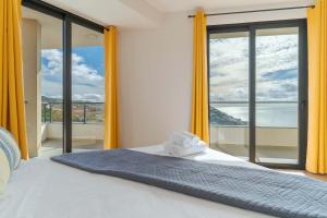 a bedroom with a bed with a large window at Banana Tree in Câmara de Lobos