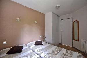 two beds in a small room with a mirror at Escapade Provençale - T2 avec cuisine et terrase privée in Digne-les-Bains