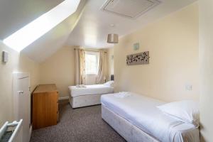 a bedroom with two beds and a window at Weaver, woodland lodge with hot tub for 12 in Oakamoor