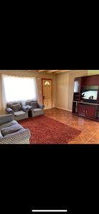Una sala de estar con un sofá y un televisor de pantalla plana. en Cabaña rivera del Captrén, en Curacautín