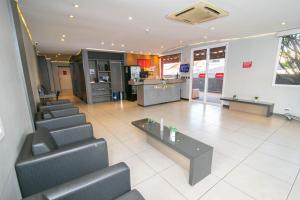 un vestíbulo con sillas y un mostrador en una tienda en I-Hotel Piracicaba, en Piracicaba