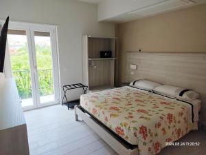 een slaapkamer met een bed en een groot raam bij GS Apartments Tropea in Tropea