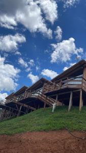 a wooden building on top of a grassy hill at Chacrinha pousada e restaurante in Caldas