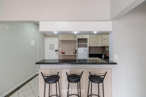 フロリアノポリスにあるEJO - Apartamentos Modernos no Centro de Floripaのカウンターのバースツール3脚付きキッチン