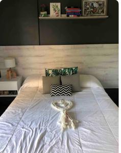 a bed with a white bedspread and a table on it at Ballester city in Villa Ballester