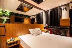 a bedroom with a large bed in a room at Motel Jardim Secreto in Santo André
