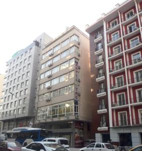 een hoog gebouw met auto's geparkeerd voor het bij Tac Hotel in Ankara