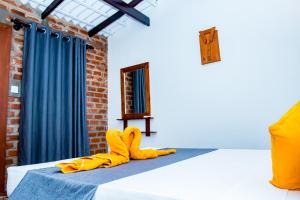 a bed with yellow pants and yellow shoes on it at Villa Manda Transit Home in Katunayake
