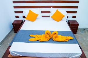 a bed with two pairs of yellow shoes on it at Villa Manda Transit Home in Katunayake