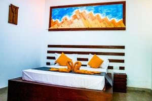 a bedroom with a bed with a painting on the wall at Villa Manda Transit Home in Katunayake