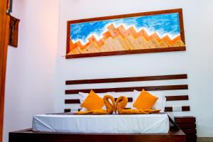 a bedroom with a bed with a painting on the wall at Villa Manda Transit Home in Katunayake