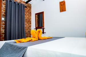 a bed with a yellow blanket and yellow socks on it at Villa Manda Transit Home in Katunayake