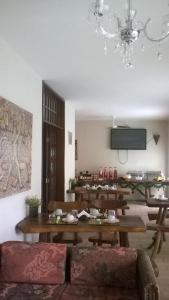 a dining room with wooden tables and a chandelier at Pousada Pura Vida in Maceió