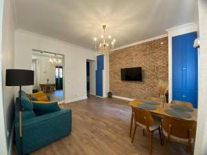 Una sala de estar con un sofá azul y una mesa. en Apartments MARGARITA, en Tiflis