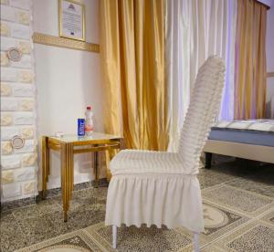 a white chair in a room with a bed and a table at Pension Laatzen - by Dzafer & Sohn wo Erholung sich Lohnt in Hannover